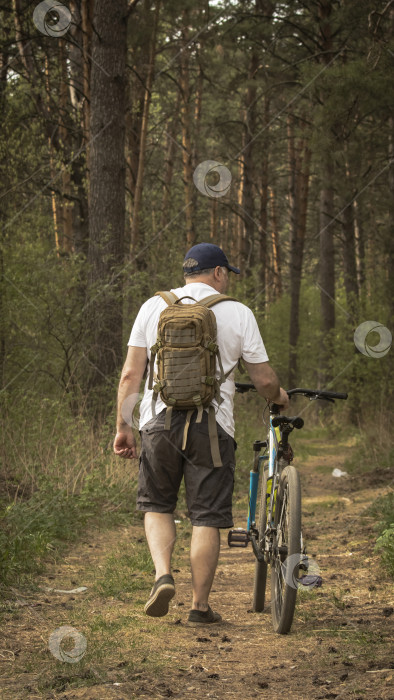 Скачать Мужчина с велосипедом в лесу фотосток Ozero