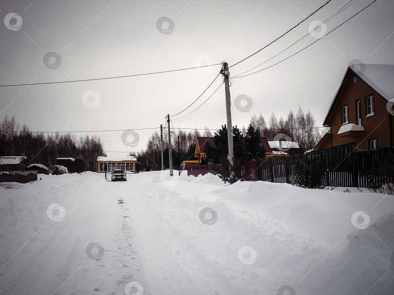 Скачать Заснеженный дачный поселок в пасмурный день фотосток Ozero