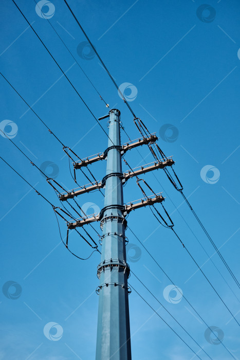 Скачать Современная металлическая опора линии электропередач на фоне ясного синего неба. фотосток Ozero