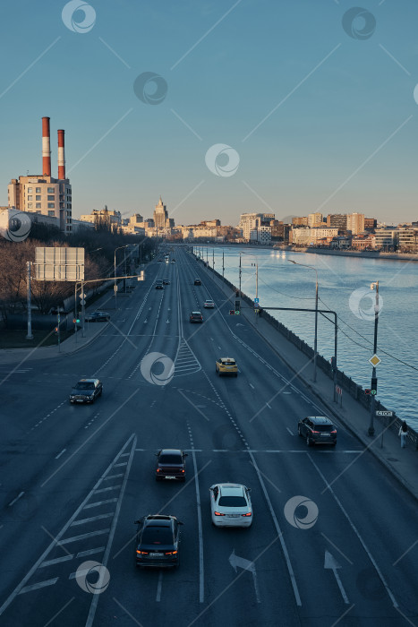 Скачать Москва, Россия, 22.03.26. Панорамный вид на набережную и Москву-реку с автомобильным трафиком на закате. фотосток Ozero