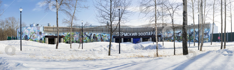 Скачать Здание нового Пермского зоопарка, украшенное иллюстрациями с изображением животных. Вход. Зимний городской заснеженный пейзаж. 18.03.2026 фотосток Ozero