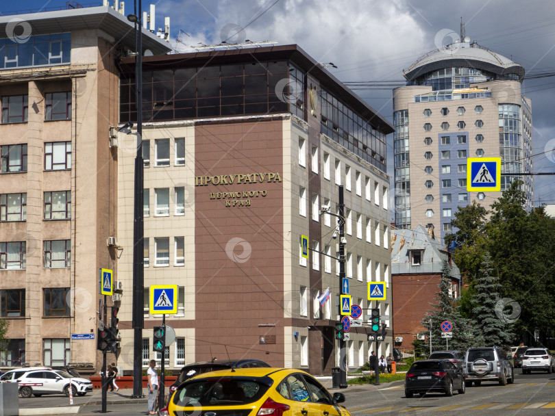 Скачать Здание прокуратуры Пермского края на Октябрьской площади в городе Перми. Пересечение Комсомольского проспекта и улицы Луначарского. По проезжей части едут автомобили. 30.07.2025 фотосток Ozero