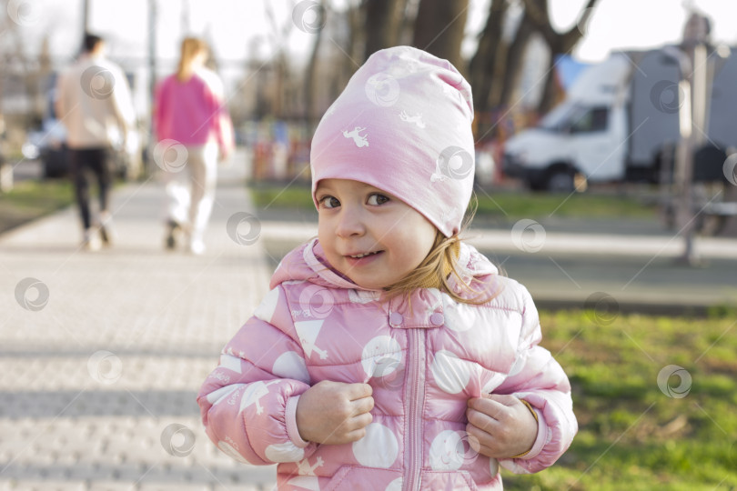 Скачать Портрет маленькой смеющейся белокурой девочки на природе с размытым фоном фотосток Ozero
