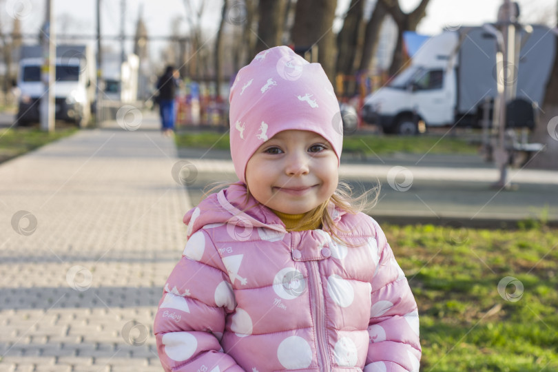 Скачать Портрет маленькой смеющейся белокурой девочки на природе с размытым фоном фотосток Ozero