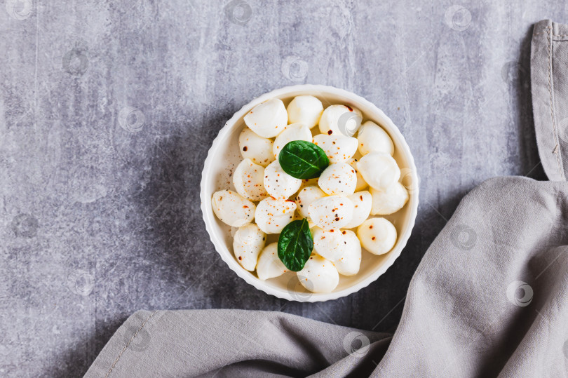 Скачать Крупный план сыра моцарелла в виде маленьких шариков в миске на столе вид сверху фотосток Ozero