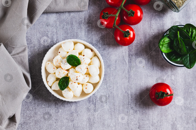 Скачать Сыр Моцарелла в виде маленьких шариков в миске на столе вид сверху фотосток Ozero