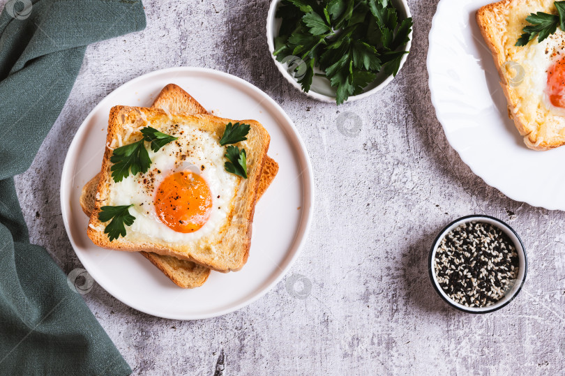 Скачать Яйцо, запеченное в кусочках хлеба на тарелке на столе вид сверху фотосток Ozero