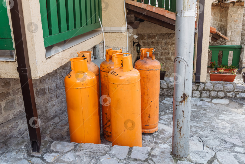 Скачать Старый баллон из оранжевой стали с газовым баллоном из пропан бутана, хранящийся на заднем дворе фотосток Ozero