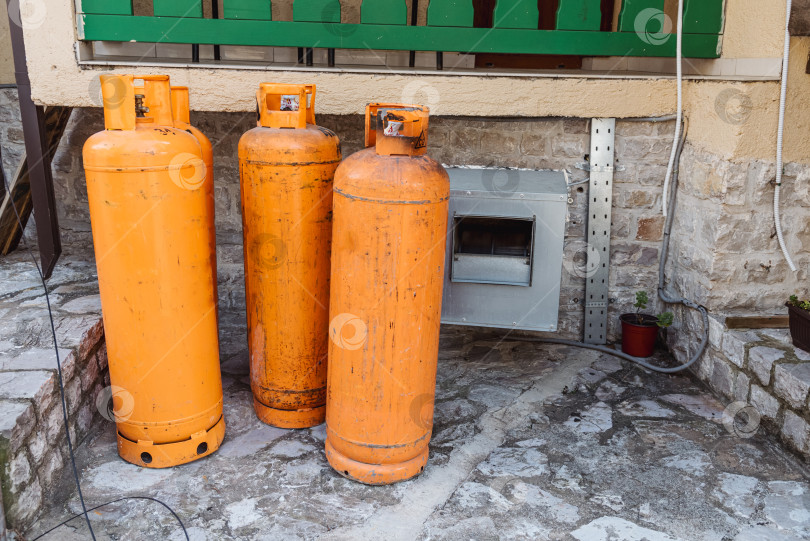 Скачать Старый баллон из оранжевой стали с газовым баллоном из пропан бутана, хранящийся на заднем дворе фотосток Ozero
