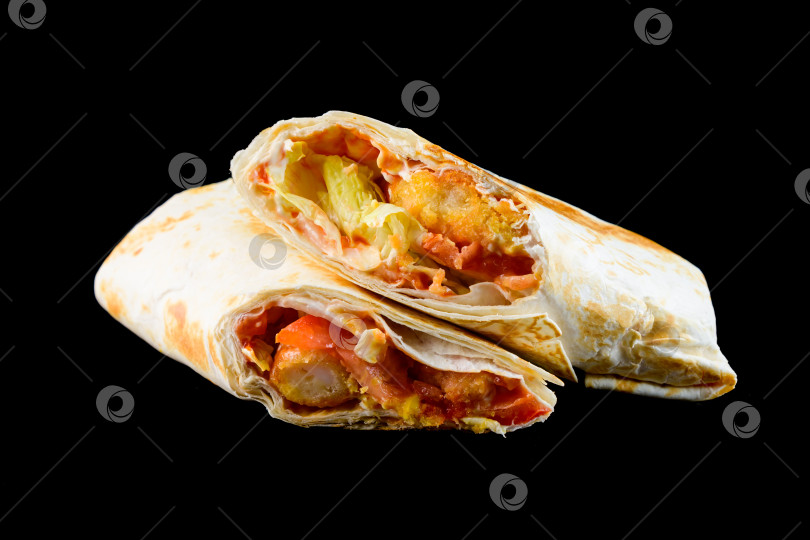 Скачать Нарезанный пополам свежий цыпленок в форме цезаря с хрустящими помидорами-наггетсами и листьями салата на черном фоне, вид сбоку крупным планом, вкусная пикантная закуска для меню фотосток Ozero