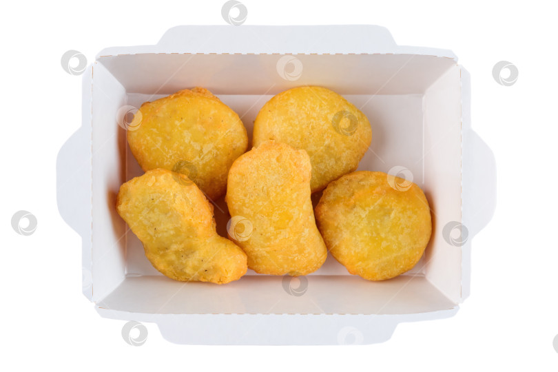 Скачать Хрустящие золотистые куриные наггетсы в белой бумажной упаковке на вынос на белом фоне вид сверху крупным планом на плоской тарелке с разделителем для копий вкусная пикантная закуска фотосток Ozero