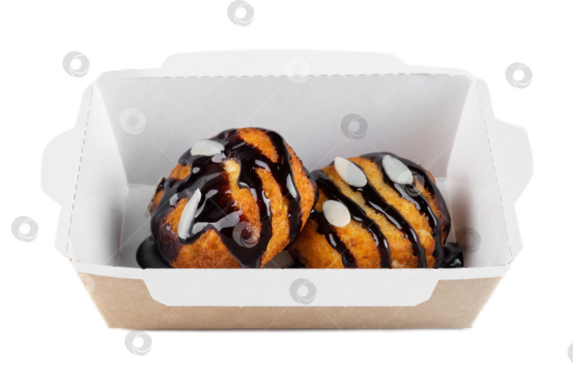 Скачать Сладкое заварное печенье с шоколадным соусом и миндальными хлопьями в картонной коробке на вынос на белом фоне, вид сбоку, без людей. фотосток Ozero