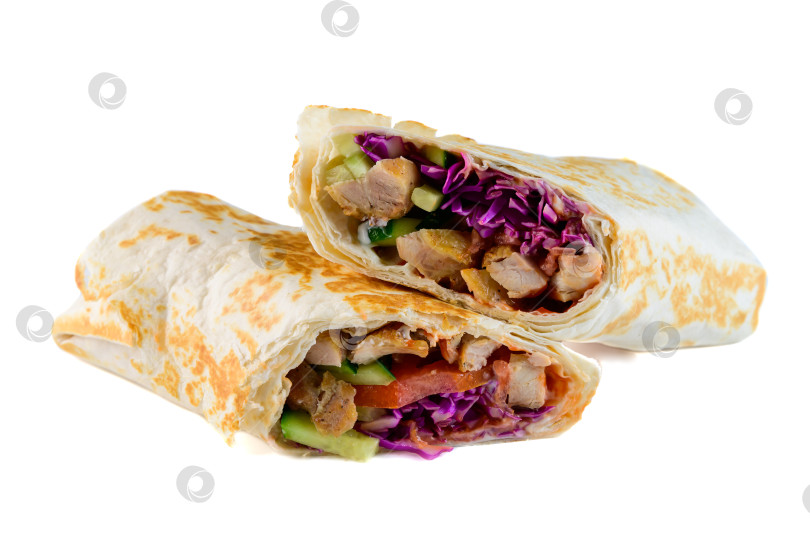 Скачать Свежая куриная шаурма в обертке, разрезанная пополам, с красной капустой и огурцом на белом фоне, вид сбоку с места для копирования вкусная пикантная мясная закуска фотосток Ozero