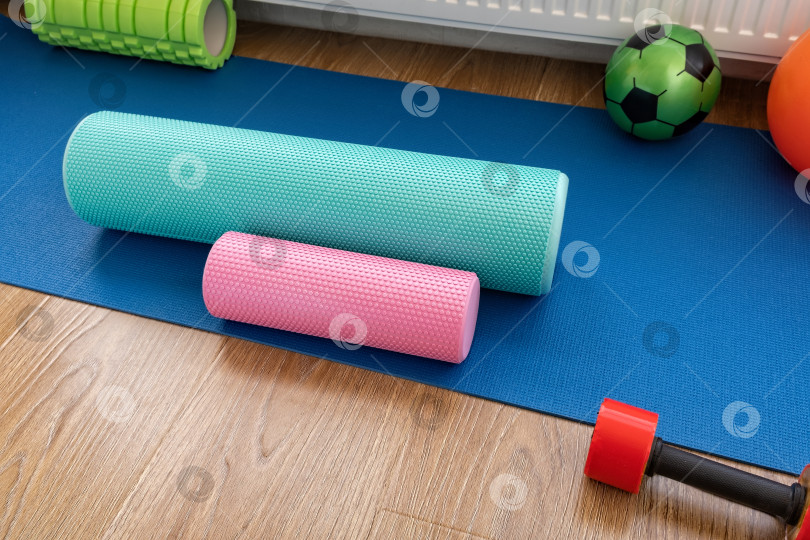 Скачать Различные виды поролоновых роликов и оборудования на синем коврике для упражнений в тренажерном зале дома фотосток Ozero