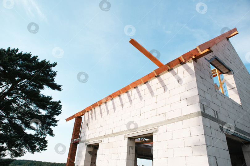 Скачать Современный блочный дом на стадии укладки лаг, сборка каркаса крыши, европейский стиль строительства, финансируемый за счет ипотеки, застрахованная строительная площадка. фотосток Ozero