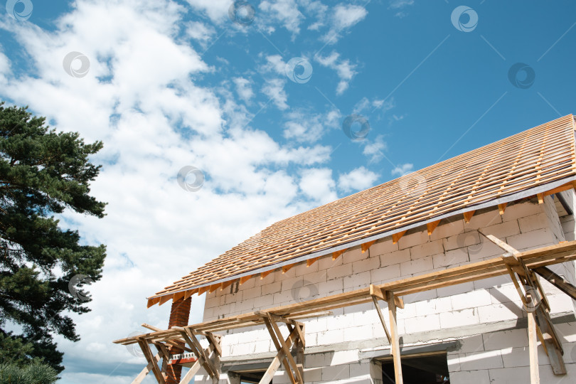 Скачать Современный дом с возведенной деревянной системой stropil на толстых каменных стенах, активной кровлей при ярком дневном свете, видимым внешним дизайном. фотосток Ozero