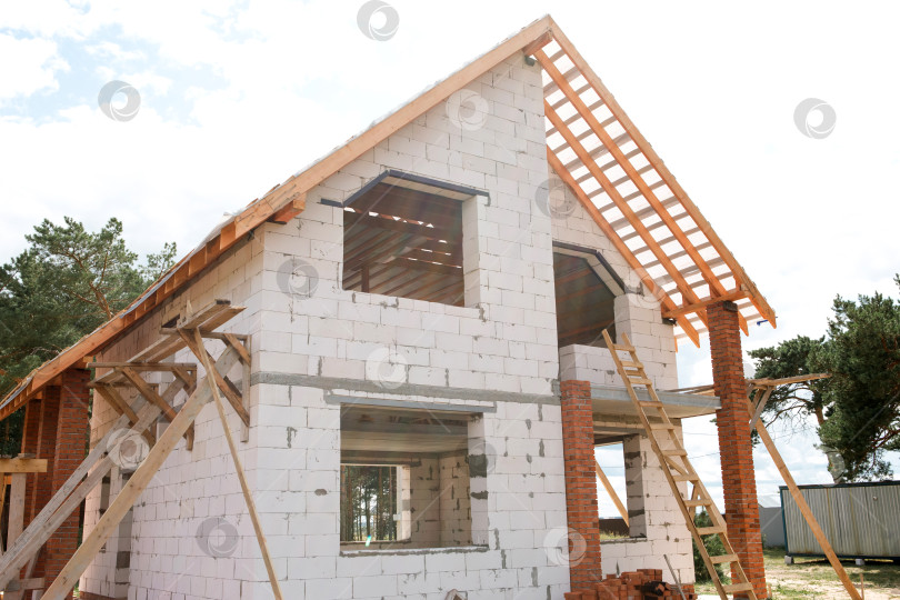 Скачать Евро-коттедж с использованием новейших технологий stropil и lag, воздушным фасадом, видимым деревянным каркасом, дом на средней стадии строительства крыши. фотосток Ozero
