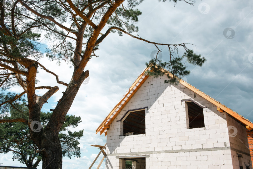 Скачать Угловая перспектива, строящийся дом в евростиле, крыша формируется из стропил и лаговой системы, сочетающих классический блочный дизайн с новым дизайном крыши. фотосток Ozero