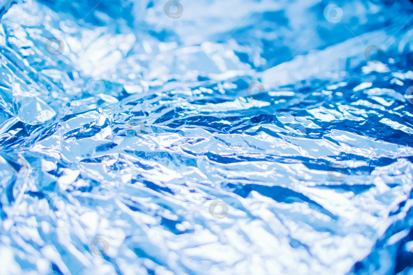 Скачать Мятая синяя фольга. Фон переливается и создает блики. фотосток Ozero