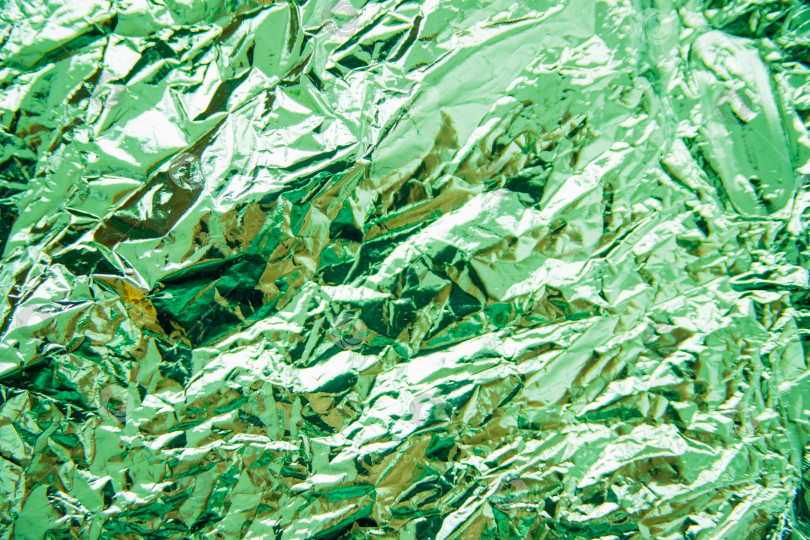 Скачать Скомканная зеленая фольга. Фон переливается и создает блики. фотосток Ozero