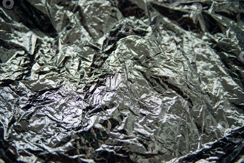 Скачать Смятая темно-серая фольга. Фон переливается и создает блики. фотосток Ozero