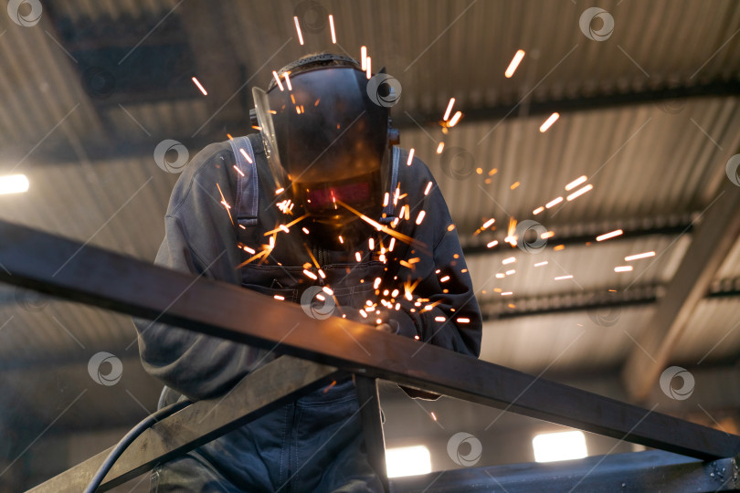 Скачать Сварочный аппарат, от которого искры эффектно разлетаются по промышленному потолку фотосток Ozero