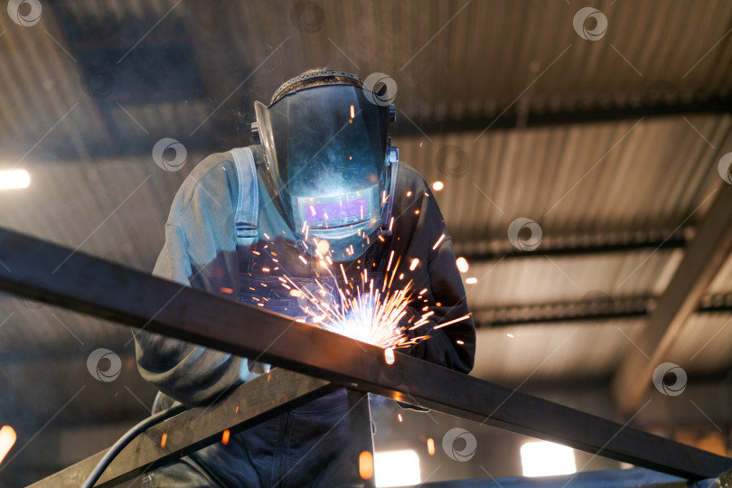 Скачать Профессиональный сварщик, создающий яркую дугу при работе со стальной балкой фотосток Ozero