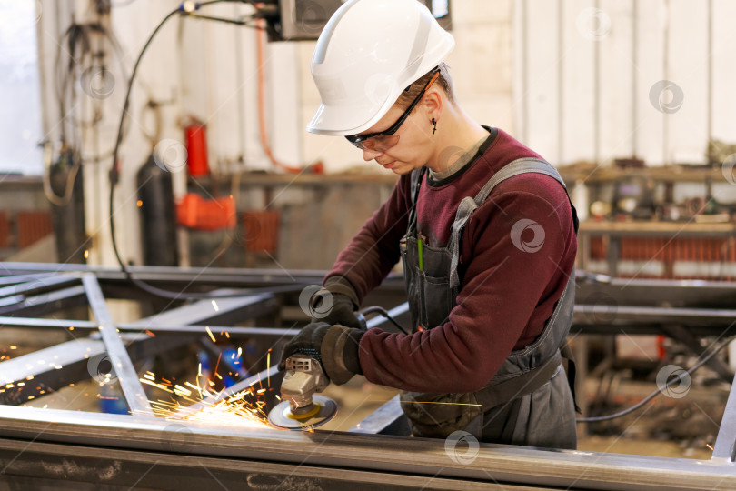 Скачать Рабочий-строитель в каске, высекающий искры из стали фотосток Ozero