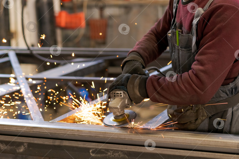 Скачать Мастер по изготовлению металла Шлифует стальную раму с летящими искрами фотосток Ozero