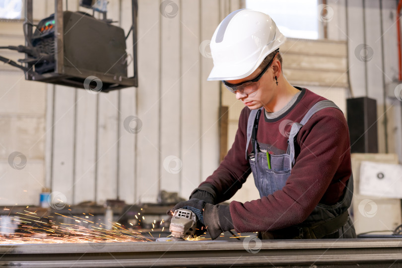 Скачать Ученик слесаря, шлифующий сталь в заводских условиях фотосток Ozero