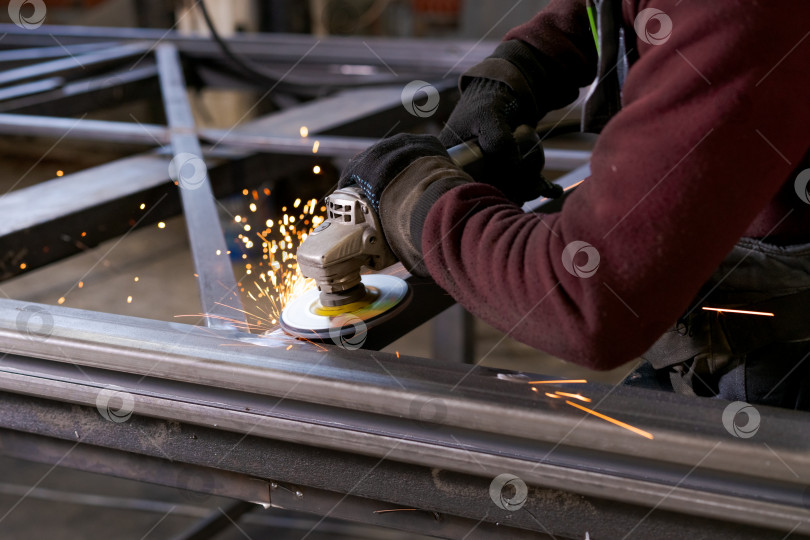 Скачать Руки мастера по изготовлению металла Шлифуют сталь так, что летят искры фотосток Ozero