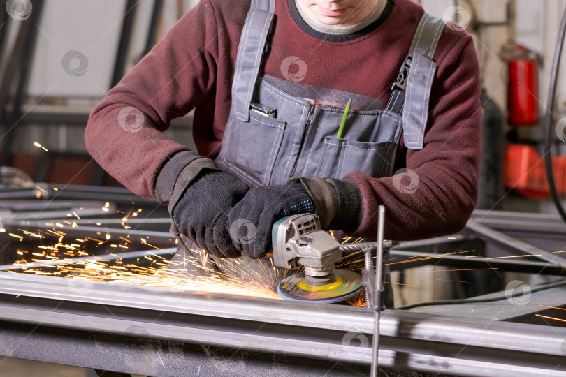 Скачать Торс промышленного рабочего, шлифующего металл с искрами фотосток Ozero