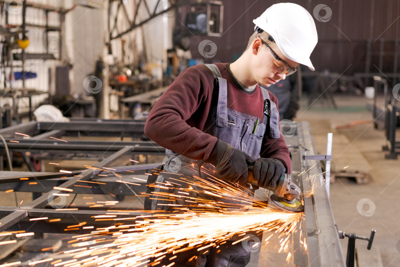Скачать Рабочий по металлу шлифует сталь с эффектным дождем искр фотосток Ozero