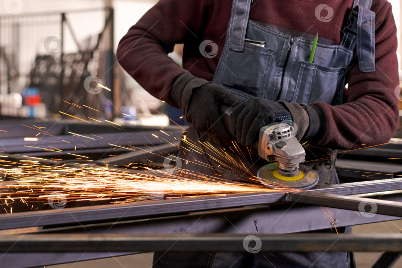 Скачать Торс металлурга, шлифующий сталь с летящими искрами фотосток Ozero