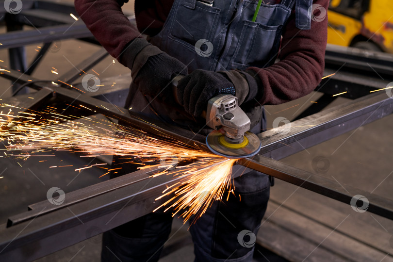 Скачать Изготовитель металла Шлифует стальную раму с желтым транспортным средством позади фотосток Ozero