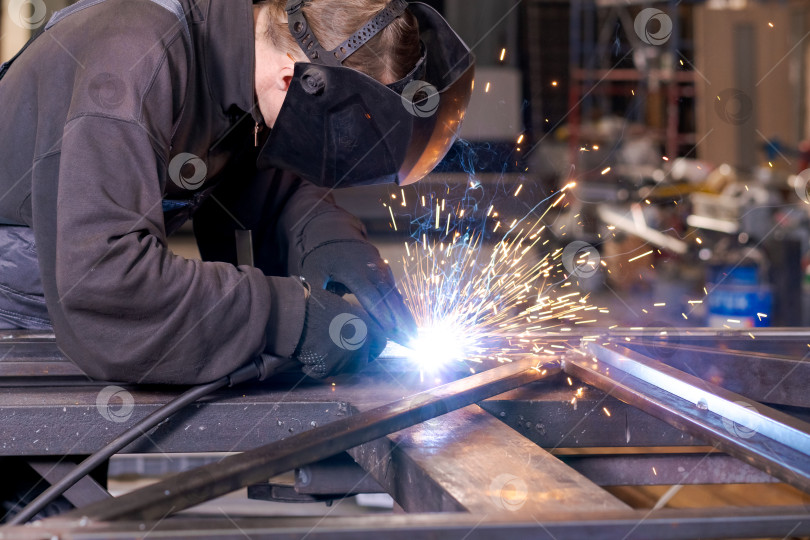 Скачать Старший сварщик, создающий интенсивные искры на стальных конструкциях фотосток Ozero