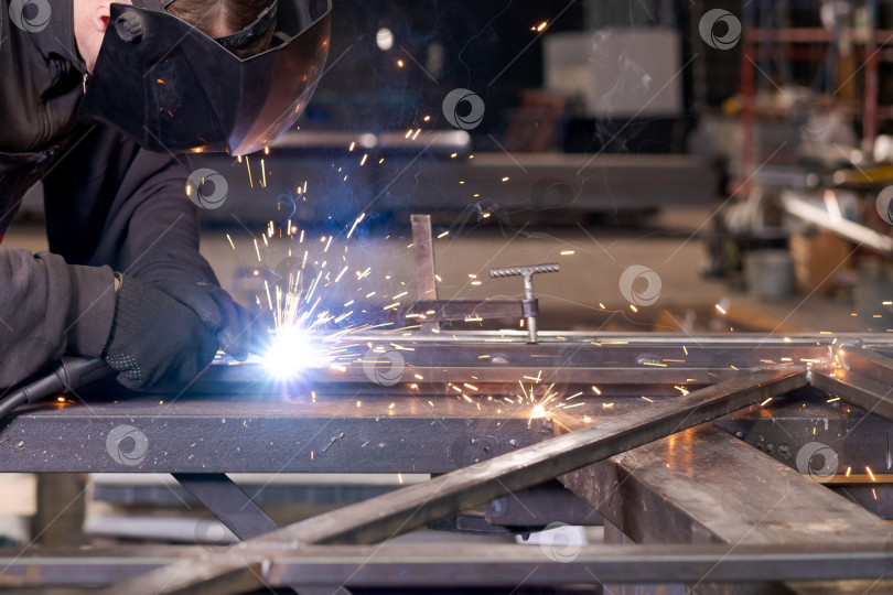 Скачать Сварщик, работающий на стальной раме с зажимом и искрами фотосток Ozero