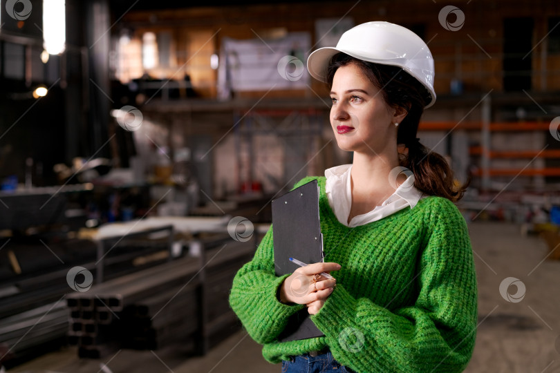 Скачать Женщина-инспектор задумчиво стоит на складе металлолома фотосток Ozero