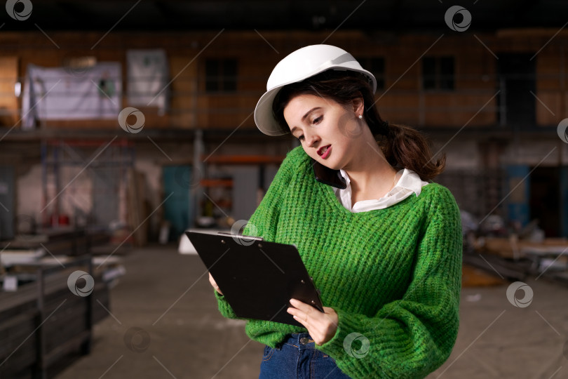 Скачать Женщина-менеджер отвечает на телефонный звонок на складе металлолома фотосток Ozero