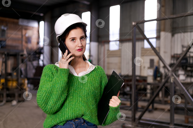 Скачать Женщина-супервайзер принимает деловой звонок на заводе фотосток Ozero