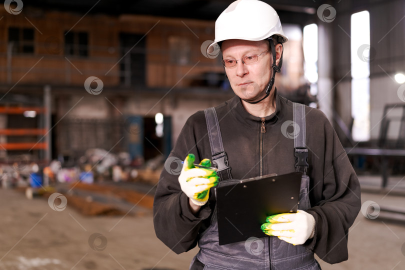Скачать Фабричный рабочий пишет в буфере обмена на складе фотосток Ozero