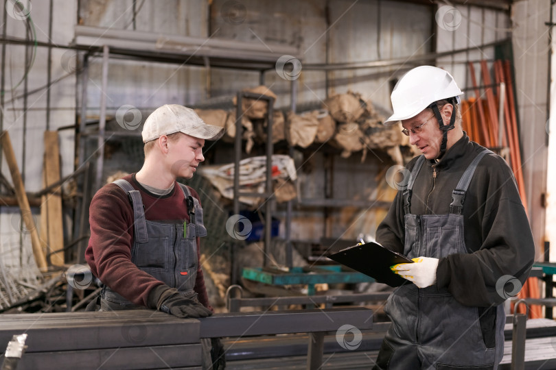 Скачать Руководитель, объясняющий задачу молодому рабочему на заводе фотосток Ozero