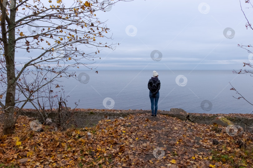 Скачать Женщина смотрит на море с Осеннего берега фотосток Ozero