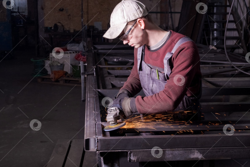 Скачать Рабочий Шлифует Металлическую Раму Ворот, Высекая Искры фотосток Ozero