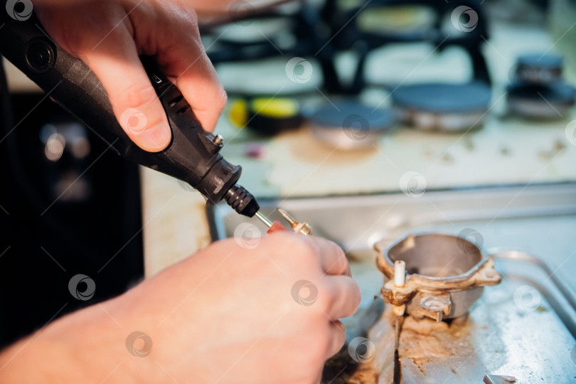Скачать Ремонт и чистка газовой панели управления. Горелку варочной панели ремонтирует мужская рука. фотосток Ozero