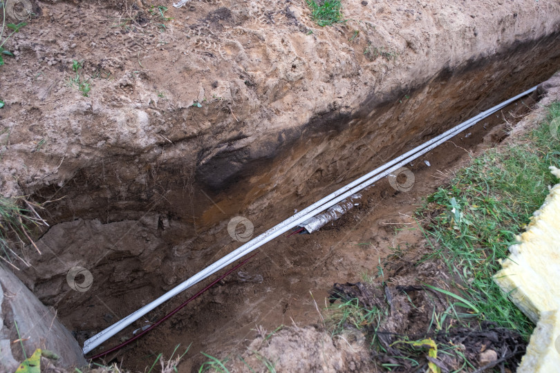 Скачать Траншея для прокладки водопровода, рытье котлована, прокладка подземных трубопроводов, изоляция трубопроводов, прокладка сантехники, фундамент для системы водоснабжения, строительные работы. фотосток Ozero