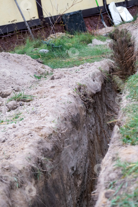 Скачать Водопроводная траншея под стеной, изолированный подводящий трубопровод, земляные работы под фундамент, инженерный канал, строительство, земляные работы, защита, техническое обслуживание, инженер, дом. фотосток Ozero