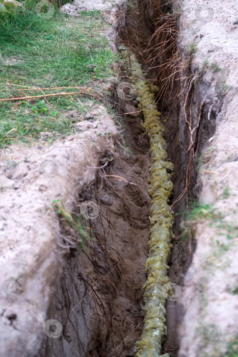 Скачать Свежевырытая траншея для изолированного трубопровода, прокладки подводящей линии, подготовки наружного фундамента, ремонта, земляных работ, защиты, инженерного обеспечения, бытового обслуживания. фотосток Ozero