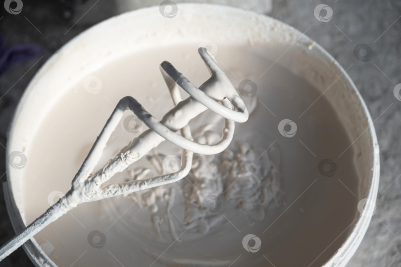 Скачать Влажная штукатурная смесь, перемешиваемая в ведре с помощью дрели-миксера, для ремонта зданий, подготовки стен к ремонту, инструмент мастеров для поверхностных и облицовочных работ. фотосток Ozero