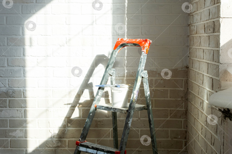 Скачать Покраска стен в помещении, стремянка и баллончик с краской, отделка поверхностей, ремонт дома, дизайн интерьера и ремонтные работы, строительные работы. фотосток Ozero